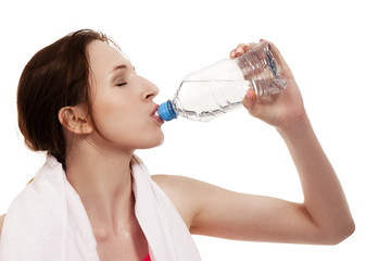 junge sportlerin trinkt wasser vor weißem hintergrund