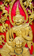 Fototapeta premium Golden giant guarding the gate of a Thai ancient temple