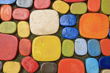 Stone wall of the house from different color of stones in a layi