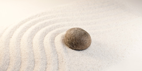 Fototapeta na wymiar pierre dans le sable simplicité méditation