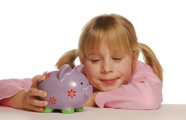 Pequeña niña sosteniendo un cerdito de ahorros.