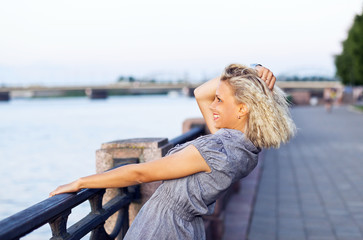 Fototapeta na wymiar happy blond woman in grey dress .