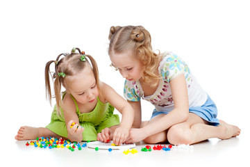 elder sister training young one to collect mosaic toy over white