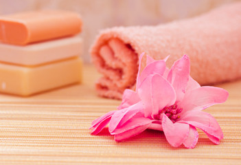 Obraz na płótnie Canvas daily spa objects, towel, soaps, pink flower