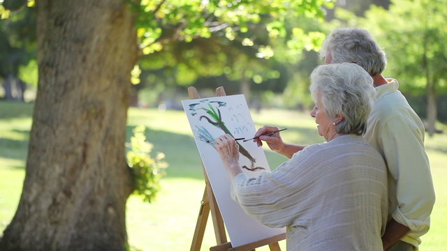 Retired people painting a tree together