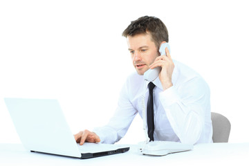 Happy business man on cell phone in front of laptop