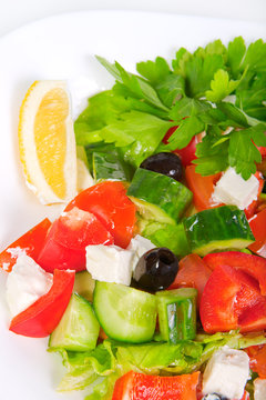 juicy fresh Greek salad in white bowl