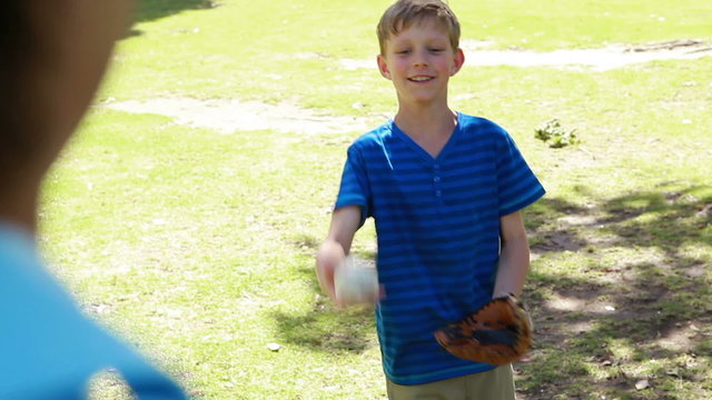 Smiling boy playing with a baseball with his father