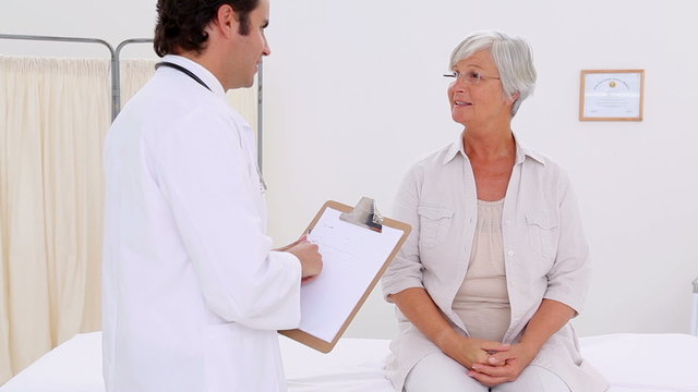 Smiling patient talking with her serious doctor