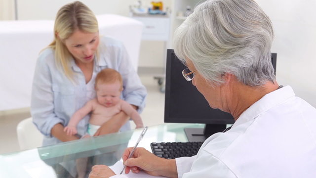 Doctor moving her fingers in front of a baby