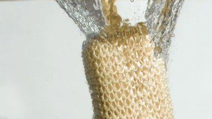loofah glove in super slow motion falling in water - Powered by Adobe
