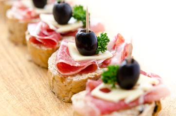 Group of sandwich appetizers with ham and cheese