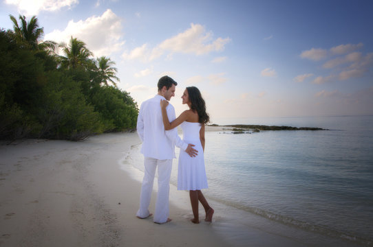 Sensual happy lovers in white clothes on the beach (Maldives)