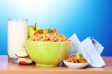 tasty cornflakes in green bowl, apples and glass of milk