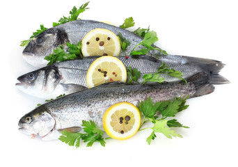 Fresh fishes with lemon, parsley and spice isolated on white