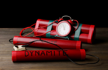 Timebomb made of dynamite on wooden table on black background