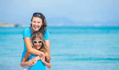 Fototapeta na wymiar Mother and her daughter having fun on beach