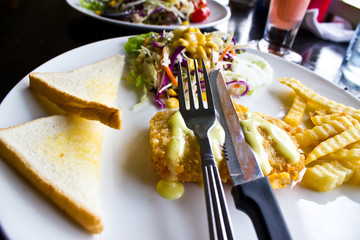 chicken steak with salad,bread and French fried potatoes