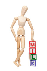 Wooden figurine with the word MILK isolated on white