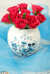 still life with a bright red roses in a beautiful vase