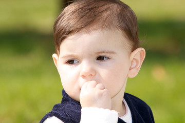 Bambina con dita  in bocca.