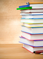 pile of books and pens on wood background