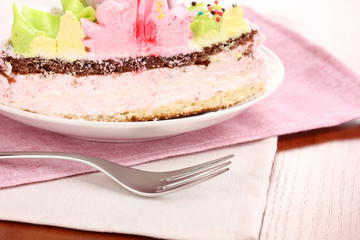Creamy cake on saucer on table close-up