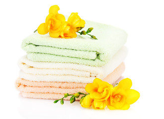 Obraz na płótnie Canvas kolorowe ręczniki i kwiaty samodzielnie na białym tle