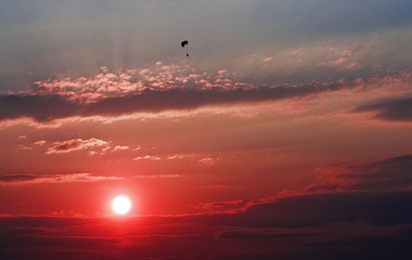 Fototapeta na wymiar Paralotnia Lone nad czerwonym zachodem słońca.