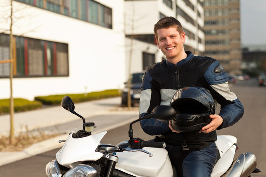 junger mit motorrad und helm