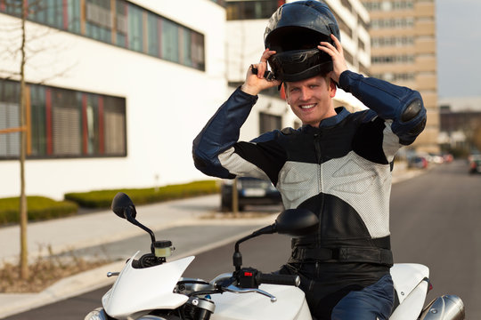 junger mit motorrad und helm