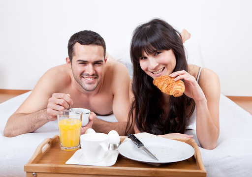 Young Couple Eating Breakfast In Bed