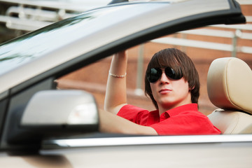 Young man driving a convertible car