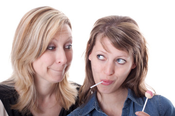 Blonde Frau möchte Lolly von brünetter Frau