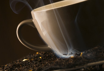 Filiżanka herbaty z dymiącymi liśćmi herbaty