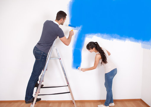 Couple painting wall at home