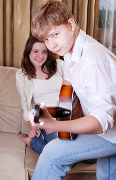 Teenage boy playing by guitar