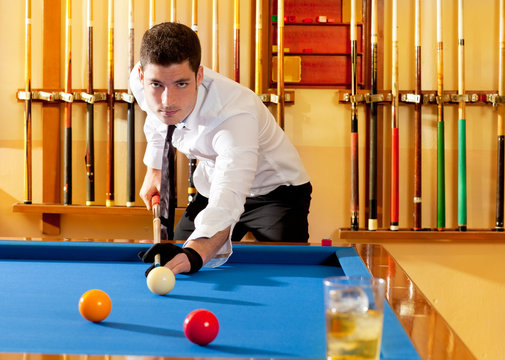 Billiard winner handsome man playing with cue and balls