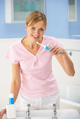 Woman cleaning teeth in bathroom