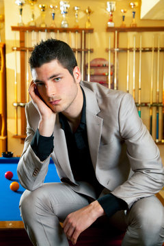 handsome man with suit sitting in billiard pool