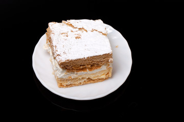 sweet  cake with cream isolated on black