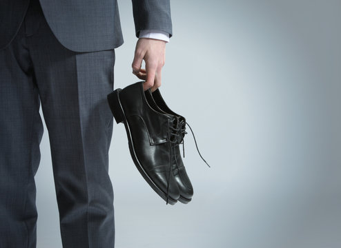 Businessman Holding The Shoes In Hand