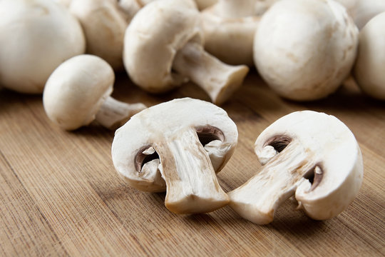 Fresh sliced mushrooms at wooden cutting board