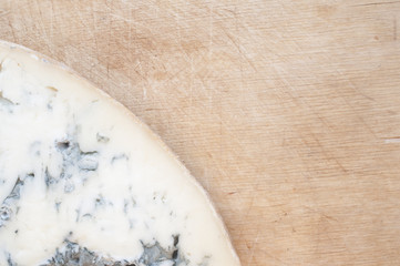 Cheese with mould on the wooden background