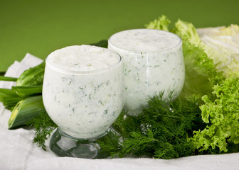 Dairy-grassy drink,  cucumber,  salad on green background