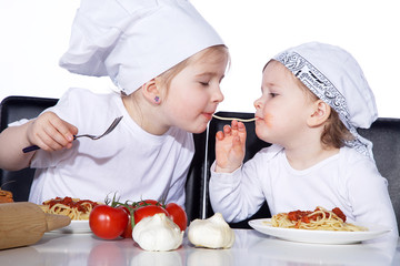 Kinder essen Spaghetti mit einer Nudel Mund zu Mund Strolch Porträt
