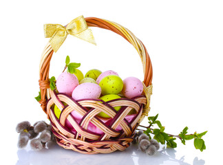 basket with Easter eggs and pussy-willow twigs isolated on white