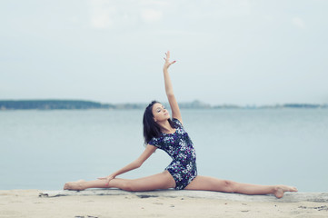 Young gymnast girl dance on beach