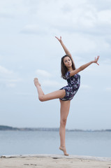 Obraz premium Young gymnast girl dance on beach