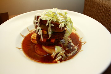 Stacked steak with vegetables and black pepper sauce